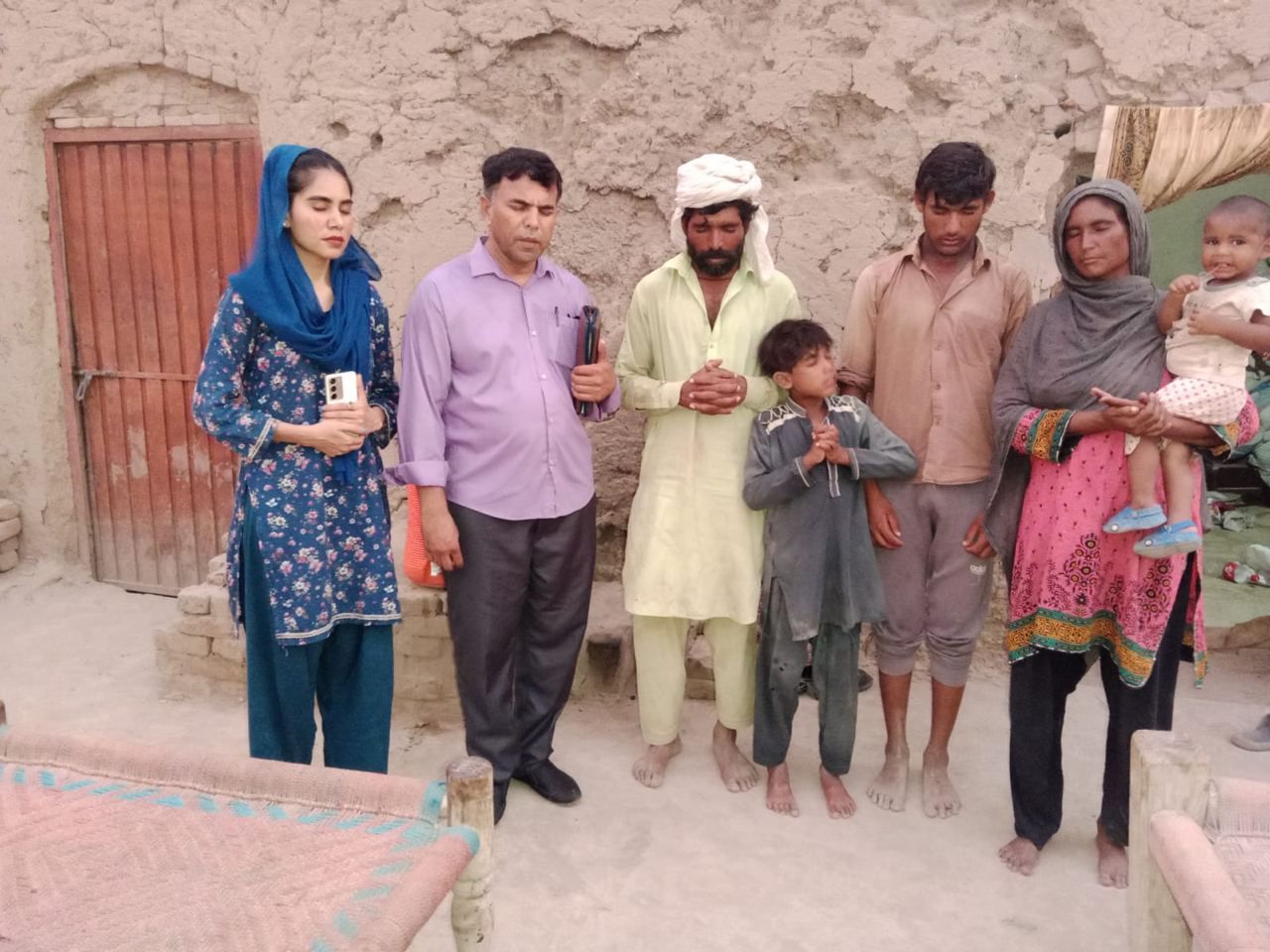 A Redeemer's Restoration International team conducting a personal interview and home visit with a family