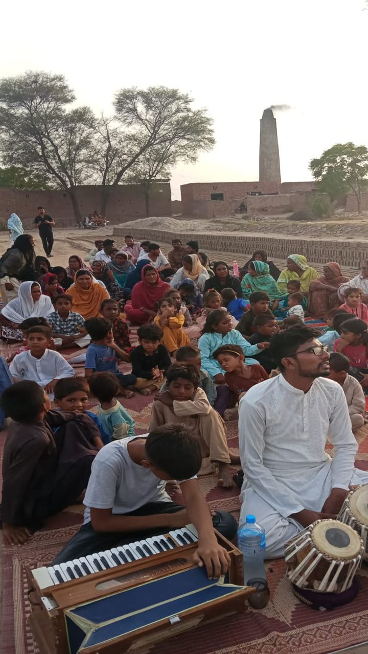 Families gathered together near a brick kiln for worship and music