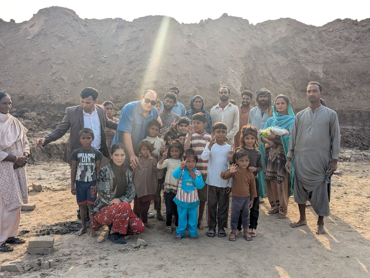 A family and their children living in bonded labor at a brick kiln, faces blurred for their protection