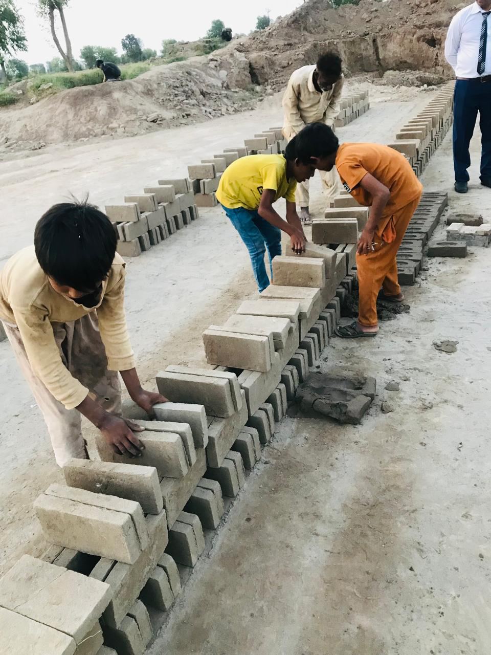 Children making bricks by hand at a brick kiln